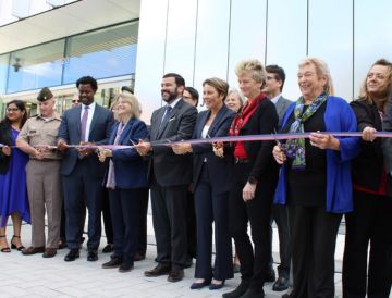 Image of U.S. DOT leadership, state and local leaders, and redevelopment Volpe Exchange Partners cut the ribbon to officially mark the opening of the new U.S. DOT Volpe Center facility in Cambridge, MA’s Kendall Square.  