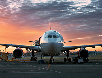 Image shows airplane in sunset.
