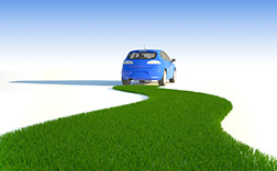 A concept image for fuel efficient cars, showing a small car with a road of green grass behind it.
