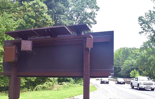 Sensors on the top of a roadway sign monitor nearby traffic.