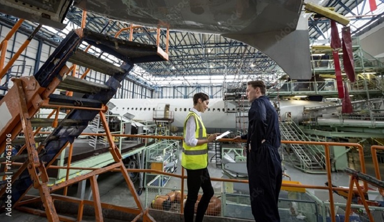 Two people standing in a airhanger