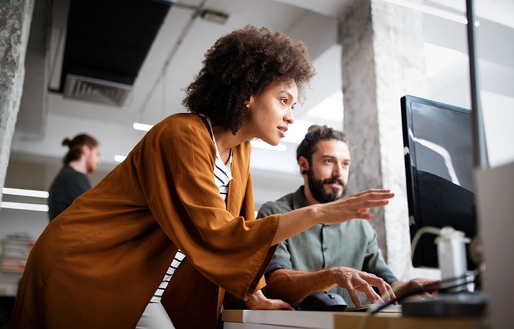 Two people looking at a computer in a modern office space