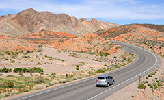 Image of a car driving down a desert highway