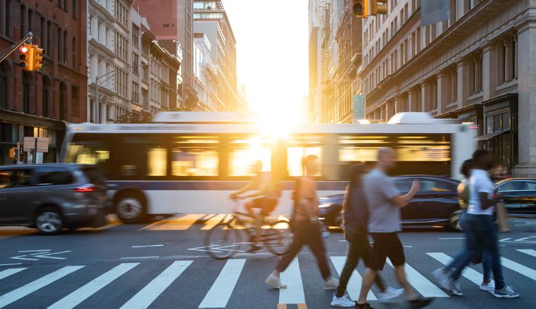People, cars, bikes, buses at busy NYC intersection