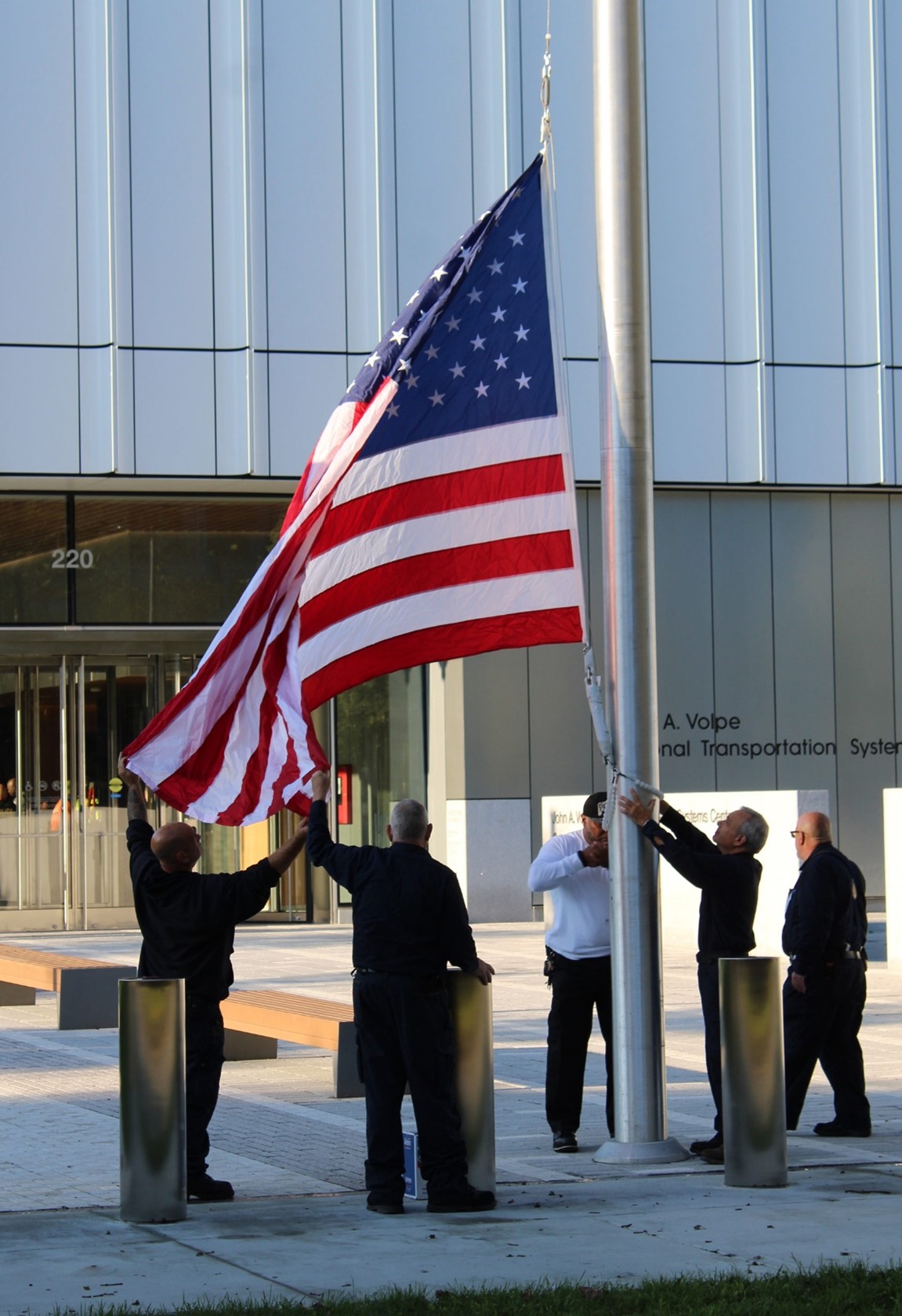 Image of the American flag being raised for the first time at the new U.S. DOT Volpe Center