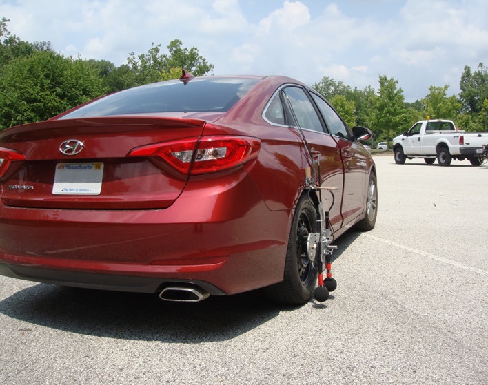 Automobile with noise emission detector attached to the rear wheel.