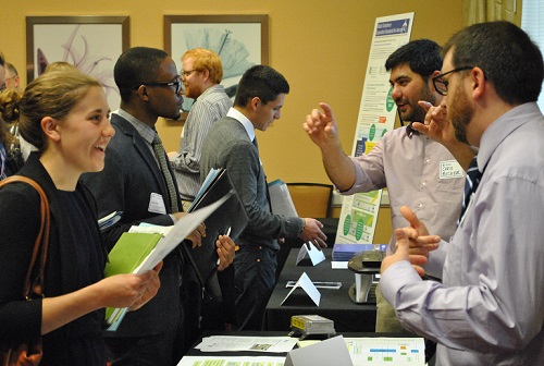 Prospective employees speak to Volpe staff during a recent job fair. (Volpe photo) A crowded room of young professionals speak to Volpe staff across tables in a conference room.