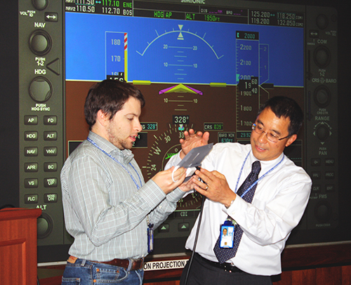 One staff member shows another how to use a device