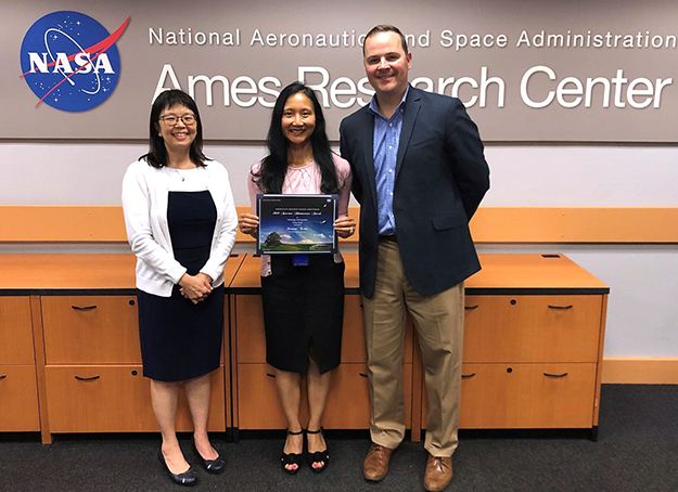 Sarasina Tuchen at NASA holding up her award, with Jason Glaneuski and Katharine Lee.