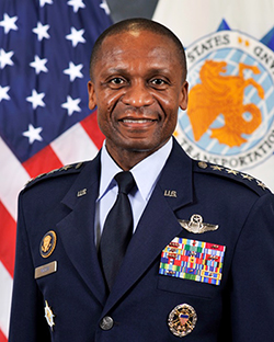 General Darren McDew stands in military uniform in front of an American flag