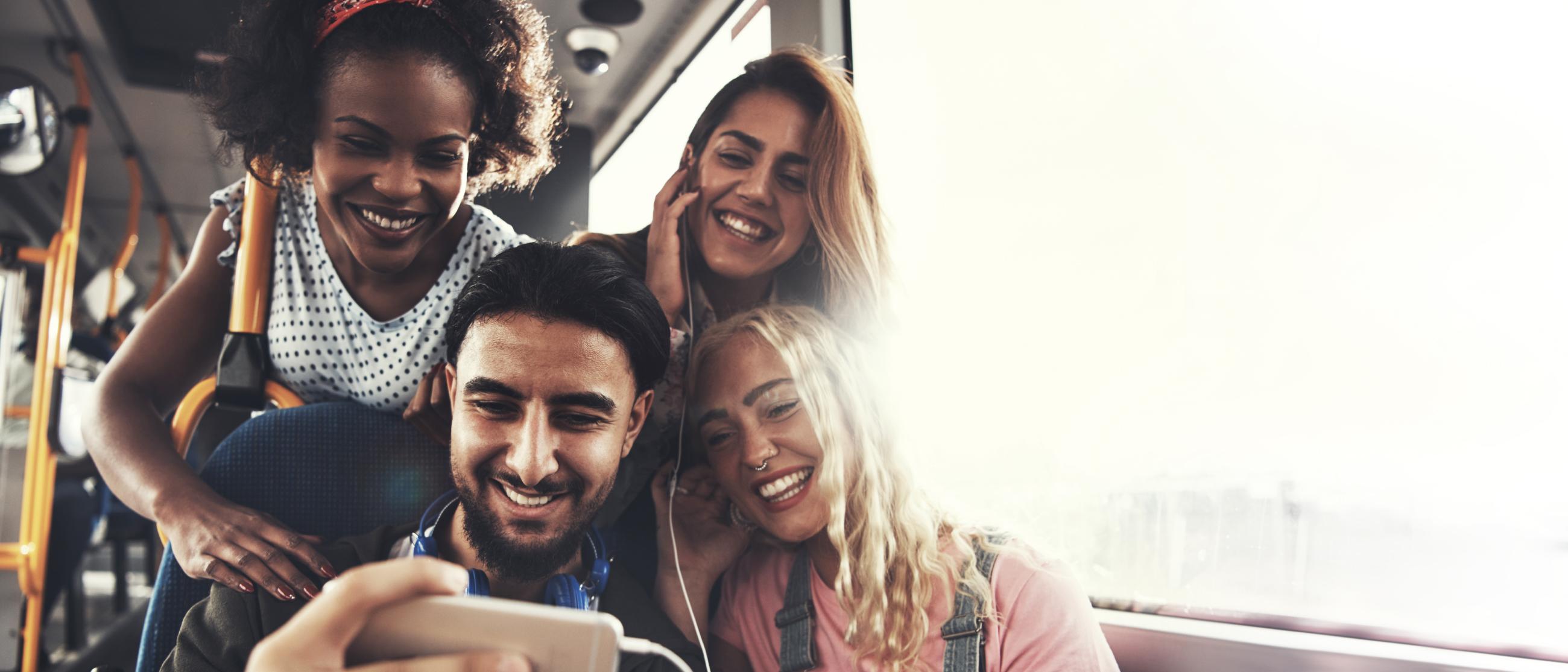 A group of people on a bus looking at a phone