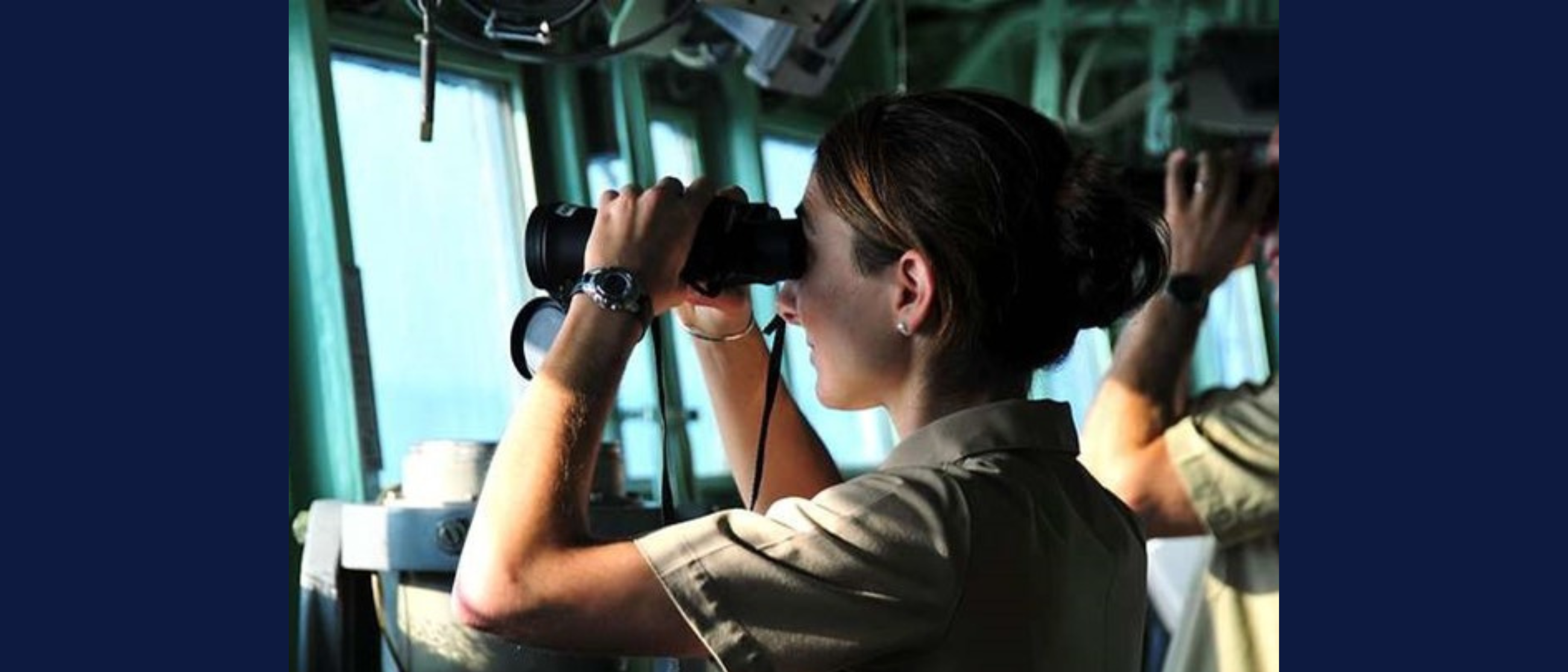 Image shows woman with binoculars looking out at sea.