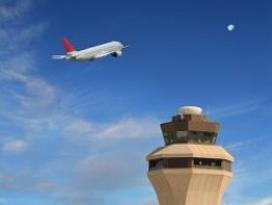 Air traffic control tpwer with plane in background.