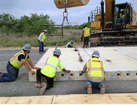 Workers install precast concrete pavement