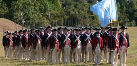 Reinactors dressed up as historical militiamen standing in formation