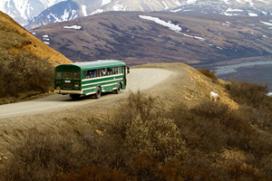 Denali National Park Shuttle driving on a winding road through the mountains