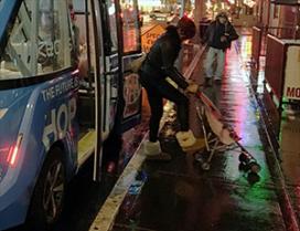 A woman steps off of a shuttle at night
