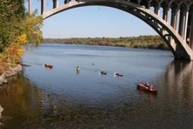 Canoers paddling under Ford Bridge on the Mississippi River in Minneapolis. (National Park Service photo) Canoers paddling under a bridge on the Mississippi River.