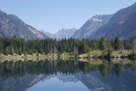 A mountain range and forest reflected in a lake