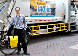 Side guards are installed on large trucks to protect bicyclists and pedestrians from falling underneath the vehicle. (Volpe photo) A Volpe staff member stands next to a truck with a side guard.